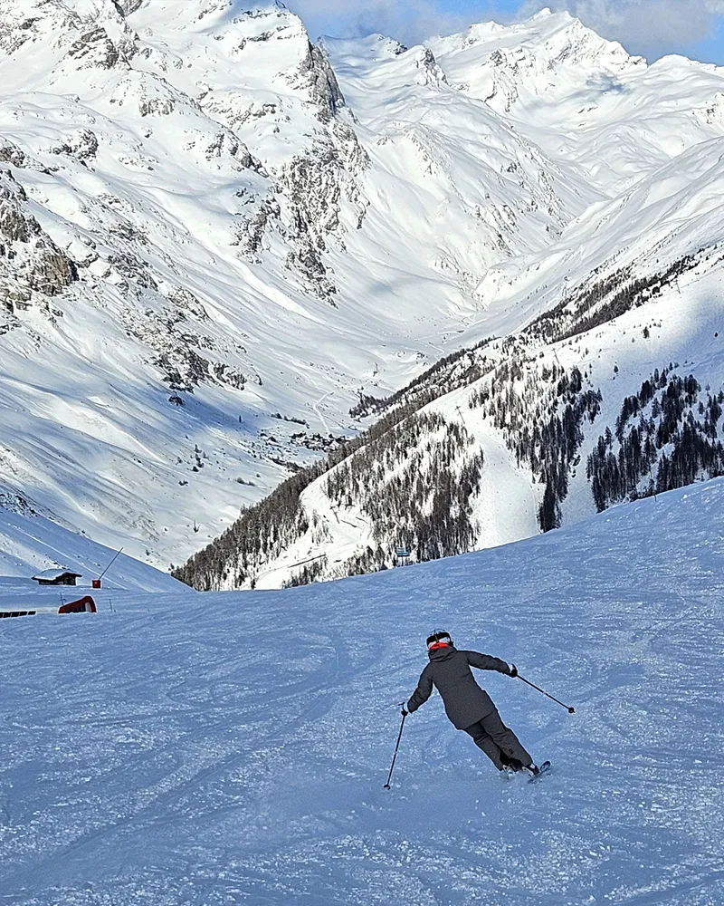 Skier overlooking Val d'Isère valley on a clear day