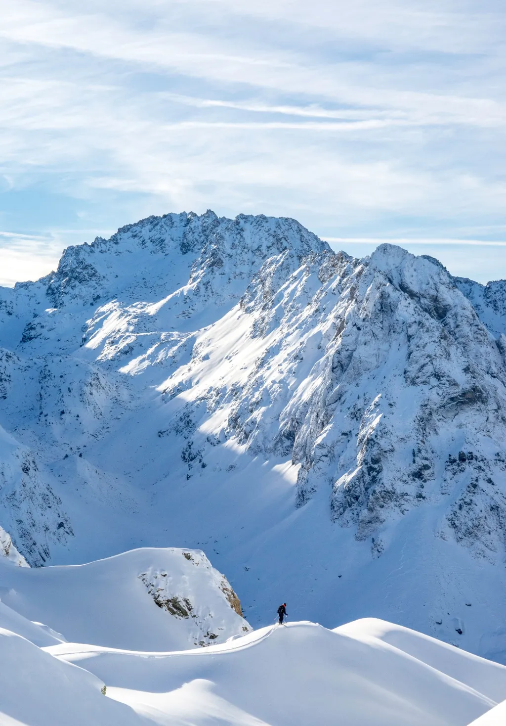 Lone skier in a vast alpine landscape