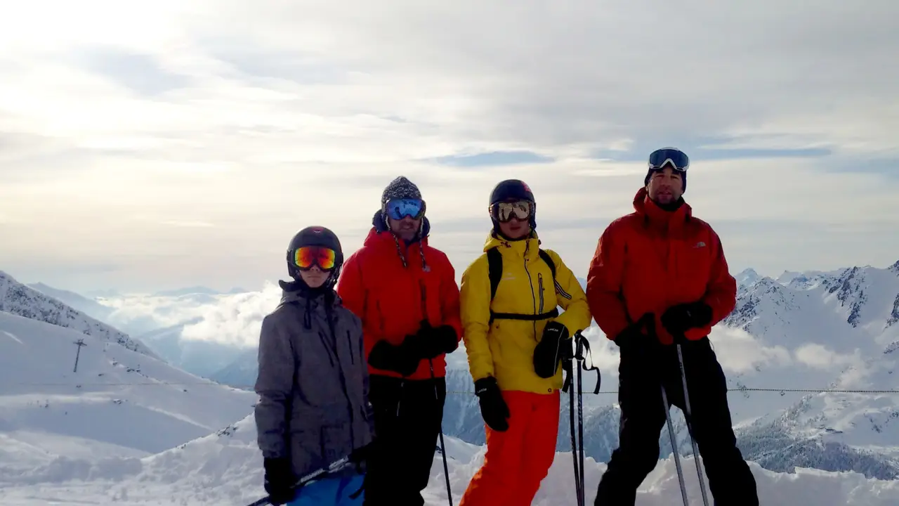 Family group of skiers above a sea of clouds