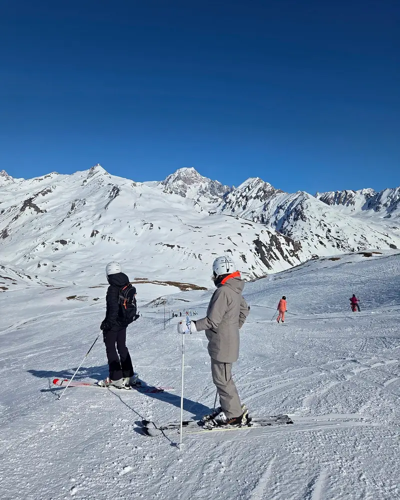 Two skiers looking at Mont Blanc from a piste in the Espace San Bernardo