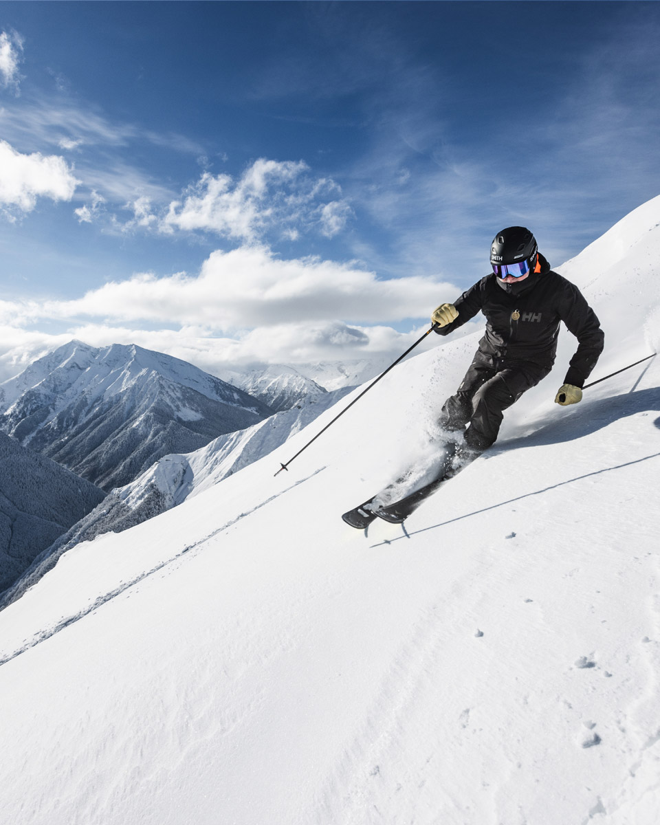 Skier carving down a steep alpine slope