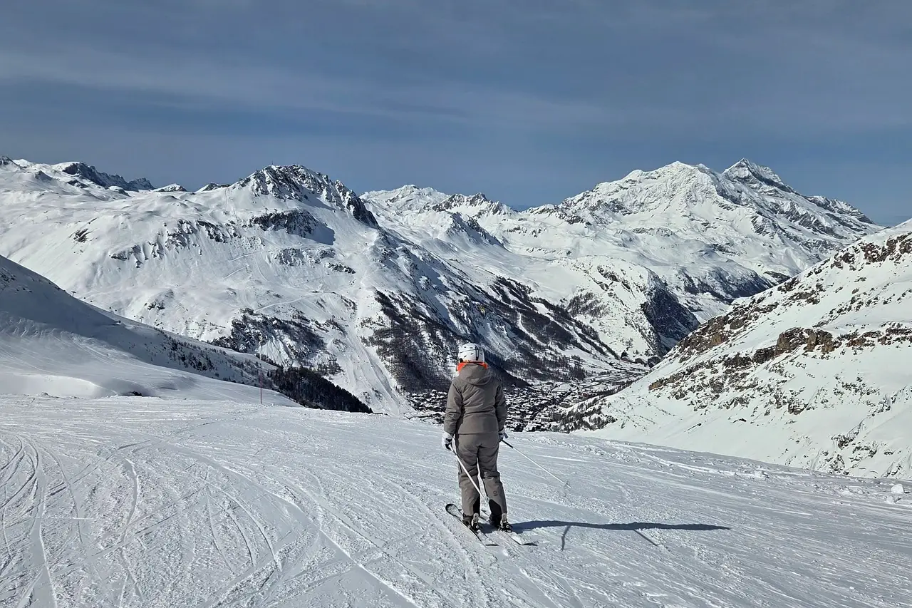 Skier on a piste looking down at the village of Val d'Isère